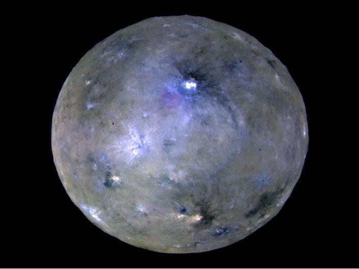 This enhanced color image of Ceres' surface was made from data obtained on April 29, 2017, when NASA's Dawn spacecraft was exactly between the sun and Ceres. Dawn's framing cameras took images of Ceres with a clear filter as well as five different color filters.  Images combining these different color filter perspectives reveal fine details of Ceres' surface. For example, they emphasize the distinct compositions and textures of the material ejected from craters. The brightest region on Ceres, called Cerealia Facula, is highlighted in Occator Crater in the center of this image. Vinalia Faculae, the set of secondary bright spots in the same crater, are located to the right of Cerealia Facula.  One of the darkest regions on Ceres is next to Occator, and represents ejected material from the impact that formed the crater. The ejected material forms a large arc that extends over several hundred kilometers, below the center of Ceres in this image. That material's distribution is partly determined by Ceres' rotation.  Other craters also show a mixture of bright and dark regions. While the bright areas are generally identified as salt-rich material excavated from Ceres' crust, the origin of the dark material remains to be explained. It may have been excavated from a different layer within Ceres' subsurface than the rest of the ejecta blanket. Scientists will continue analyzing the color data to look for clues about the nature of the different materials on Ceres.  The blueish color is generally found in association with young craters. Scientists believe the color relates to processes that occur when an impact ejects and redistributes material on the surface. The continuous bombardment of Ceres' surface by micrometeorites alters the texture of the exposed material, leading to its reddening.  This image was taken altitude of about 12,000 miles (20,000 kilometers).  https://photojournal.jpl.nasa.gov/catalog/PIA21406