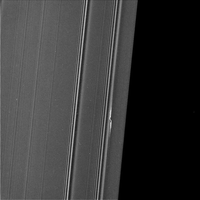 The propeller informally named "Earhart" is seen in this view from NASA's Cassini spacecraft at much higher resolution than ever before. This view, obtained on March 22, 2017, is the second time Cassini has deliberately targeted an individual propeller for close-up viewing during its ring-grazing orbits, after its images of Santos-Dumont (PIA21433) a month earlier. The biggest known propeller, informally named "Bleriot," is slated for the third and final propeller close-up in April 2017. Propellers are disturbances in the ring caused by a central moonlet. The moonlet itself would be a few pixels wide in this view, but it is difficult to distinguish from (and may be obscured by) the disturbed ring material that surrounds it. (See PIA20525 for more info on propellers.) The detailed structure of the Earhart propeller, as seen here, differs from that of Santos-Dumont. It is not clear whether these differences have to do with intrinsic differences between Earhart and Santos-Dumont, or whether they have to do with different viewing angles or differences in where the propellers were imaged in their orbits around Saturn. Earhart is situated very close to the 200-mile-wide (320-kilometer-wide) Encke Gap, which is held open by the much larger moon Pan. In this view, half of the Encke Gap is visible as the dark region at right. The gap and the propeller are a study in contrasts. The propeller is nothing more than Earhart's attempt to open a gap like Encke using its gravity. However, Earhart's attempt is thwarted by the mass of the ring, which fills in the nascent gap before it can extend very far. Pan is a few thousand times more massive than Earhart, which enables it to maintain a gap that extends all the way around the ring. To the left of the propeller are wave features in the rings caused by the moons Pandora, Prometheus and Pan. The visible-light image was acquired by the Cassini narrow-angle camera at a distance of 69,183 miles (111,340 kilometers) from the propeller feature. Image scale is 0.4 mile (670 meters) per pixel in the radial, or outward-from-Saturn, direction. The view looks toward the sunlit side of the rings. https://photojournal.jpl.nasa.gov/catalog/PIA21437