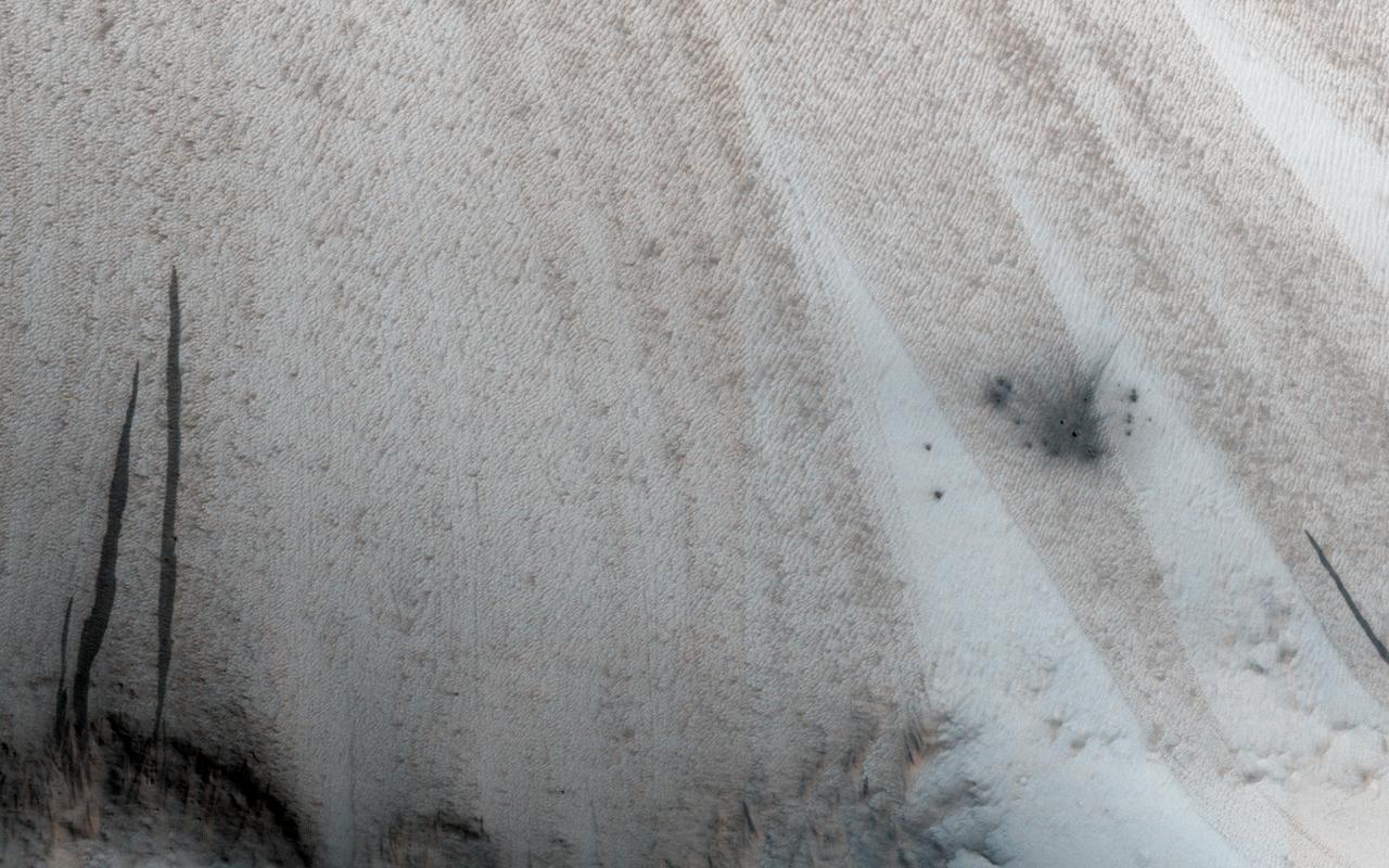 This image from NASA Mars Reconnaissance Orbiter shows a new impact site originally detected by the Context Camera onboard MRO. The crater is on a dusty slope, which also has several dark slope streaks due to dust avalanches.  A previous impact at another place on Mars triggered a major dust avalanche, but this one did not. This tells us that the dust here is more stable (stronger and/or on a lower slope).  The map is projected here at a scale of 25 centimeters (9.8 inches) per pixel. [The original image scale is 27.1 centimeters (9.8 inches) per pixel (with 1 x 1 binning); objects on the order of 81 centimeters (30 inches) across are resolved.] North is up.  http://photojournal.jpl.nasa.gov/catalog/PIA21459