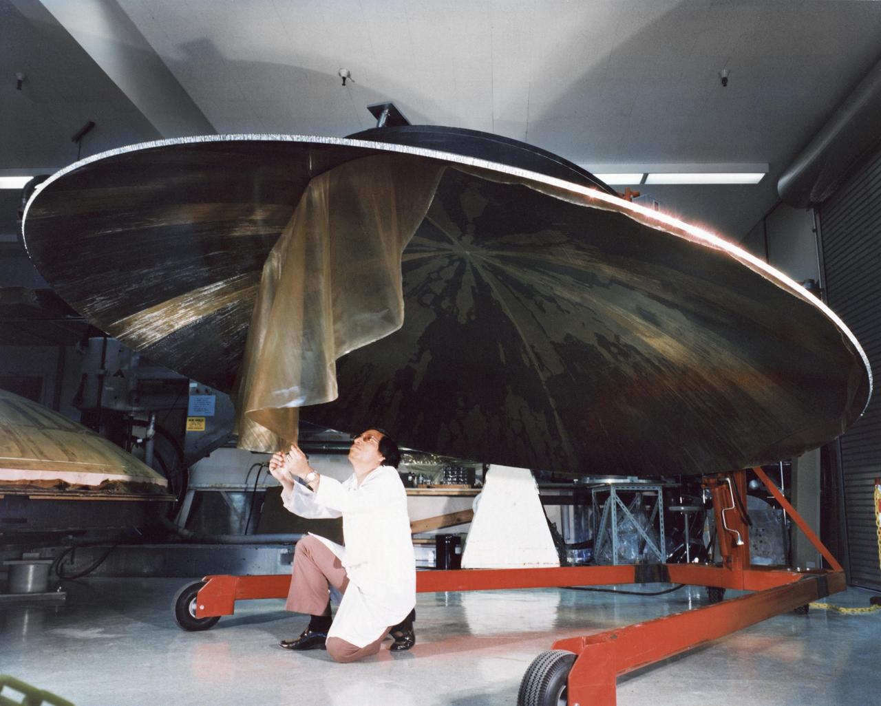 This archival photo shows an engineer working on the construction of a large, dish-shaped Voyager high-gain antenna. The picture was taken on July 9, 1976.  https://photojournal.jpl.nasa.gov/catalog/PIA21480
