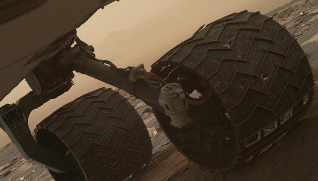 Two of the raised treads, called grousers, on the left middle wheel of NASA's Curiosity Mars rover broke during the first quarter of 2017, including the one seen partially detached at the top of the wheel in this image from the Mars Hand Lens Imager (MAHLI) camera on the rover's arm. This image was taken on March 19, 2017, as part of a set used by rover team members to inspect the condition of the rover's six wheels during the 1,641st Martian day, or sol, of Curiosity's work on Mars. Holes and tears in the wheels worsened significantly during 2013 as Curiosity was crossing terrain studded with sharp rocks on the route from near its 2012 landing site to the base of Mount Sharp. Team members have used MAHLI systematically since then to watch for when any of the zig-zag shaped grousers begin to break. The last prior set of wheel-inspection images from before Sol 1641 was taken on Jan. 27, 2017, (Sol 1591) and revealed no broken grousers. Longevity testing with identical aluminum wheels on Earth indicates that when three grousers on a given wheel have broken, that wheel has reached about 60 percent of its useful life. Curiosity has driven well over 60 percent of the amount needed for reaching all the geological layers planned as the mission's science destinations, so the start of seeing broken grousers is not expected to affect the mission's operations. Curiosity's six aluminum wheels are about 20 inches (50 centimeters) in diameter and 16 inches (40 centimeters) wide. Each of the six wheels has its own drive motor, and the four corner wheels also have steering motors. http://photojournal.jpl.nasa.gov/catalog/PIA21486