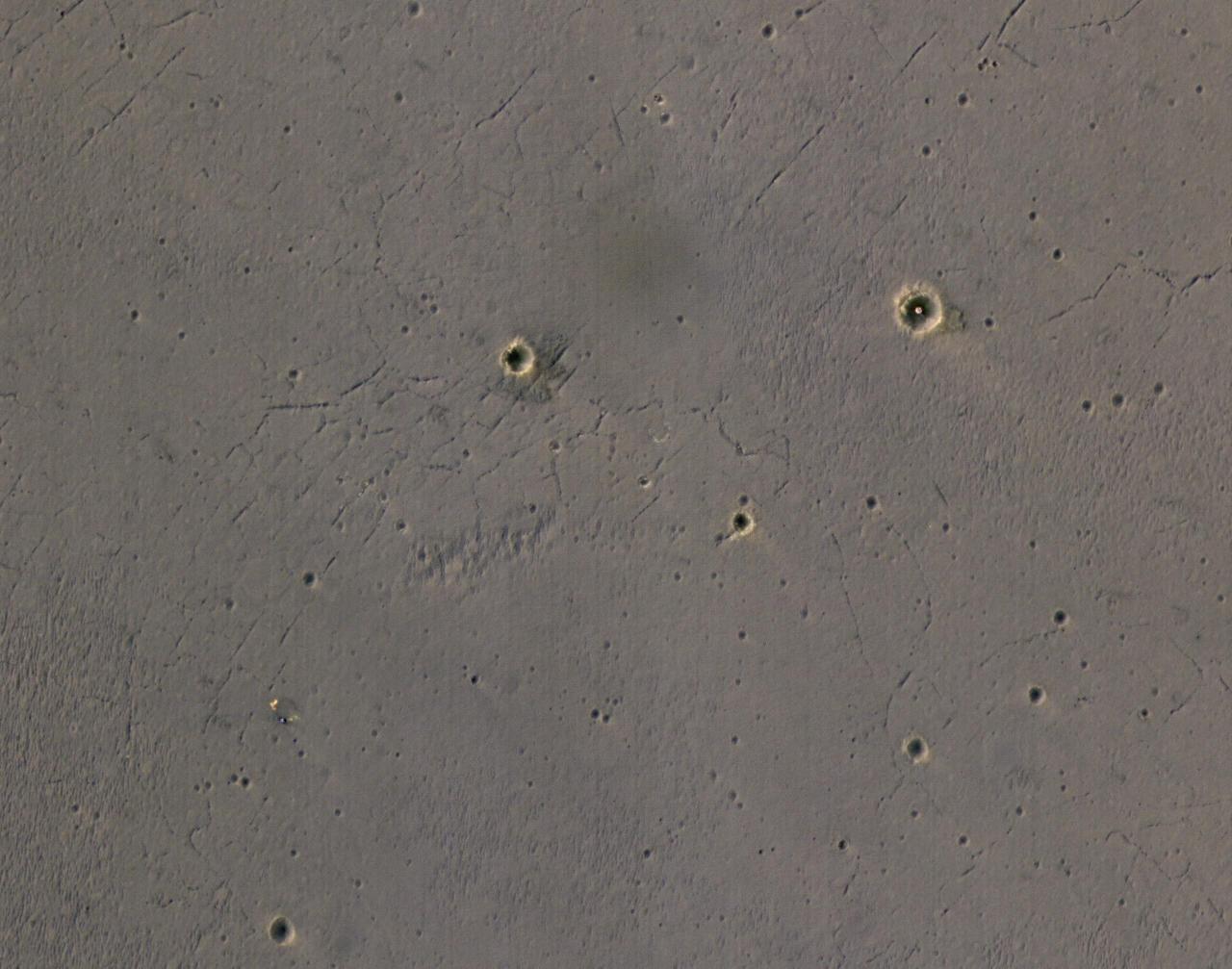 The bright landing platform left behind by NASA's Mars Exploration Rover Opportunity in 2004 is visible inside Eagle Crater, at upper right in this April 8, 2017, observation by NASA's Mars Reconnaissance Orbiter.  Mars Reconnaissance Orbiter arrived at Mars in March 2006, more than two years after Opportunity's landing on Jan. 25, 2004, Universal Time (Jan. 24, PDT). This is the first image of Eagle Crater from the orbiter's High Resolution Imaging Science Experiment (HiRISE) camera, which has optics that include the most powerful telescope ever sent to Mars.  Eagle Crater is about 72 feet (22 meters) in diameter, at 1.95 degrees south latitude, 354.47 degrees east longitude, in the Meridiani Planum region of Mars. The airbag-cushioned lander, with Opportunity folded-up inside, first hit Martian ground near the crater, then bounced and rolled right into the crater. The lander structure was four triangles, folded into a tetrahedron until after the airbags deflated. The triangular petals then opened, exposing the rover. A week later, the rover drove off (see PIA05214), and the landing platform's job was done.  The spacecraft's backshell and parachute, jettisoned during final descent, are visible near the lower left corner of this scene. The blue tint of the backshell is an effect of exaggerated color, because HiRISE combines color information from red, blue-green and infrared portions of the spectrum, rather than three different visible-light colors, so its color images are not true color.  Opportunity examined Eagle Crater for more than half of the rover's originally planned three-month mission, before driving east and south to larger craters. At Eagle, it found headline-making evidence that water once flowed over the surface and soaked the subsurface of the area. By the time this orbital image of the landing site was taken, about 13 years after the rover departed Eagle, Opportunity had driven more than 27 miles (44 kilometers) and was actively exploring the rim of Endeavour Crater, which is about 1,000 times as wide as Eagle.  https://photojournal.jpl.nasa.gov/catalog/PIA21494