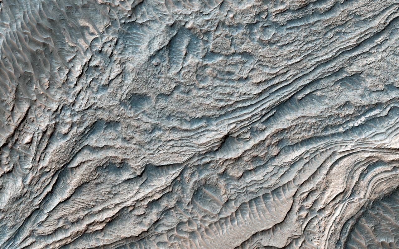 In this image from NASA's Mars Reconnaissance Orbiter, a group of steeply inclined light-toned layers is bounded above and below by unconformities (sudden or irregular changes from one deposit to another) that indicate a "break" where erosion of pre-existing layers was taking place at a higher rate than deposition of new materials.  The layered deposits in Melas Basin may have been deposited during the growth of a delta complex. This depositional sequence likely represents a period where materials were being deposited on the floor of a lake or running river.  The map is projected here at a scale of 25 centimeters (9.8 inches) per pixel. [The original image scale is 28.9 centimeters (11.4 inches) per pixel (with 1 x 1 binning); objects on the order of 87 centimeters (34.2 inches) across are resolved.] North is up.  https://photojournal.jpl.nasa.gov/catalog/PIA21580