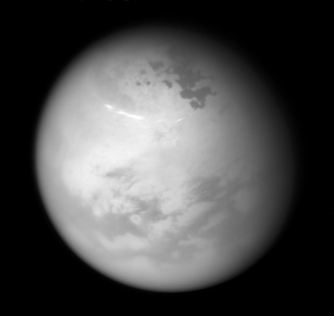 NASA's Cassini spacecraft sees bright methane clouds drifting in the summer skies of Saturn's moon Titan, along with dark hydrocarbon lakes and seas clustered around the north pole.  Compared to earlier in Cassini's mission, most of the surface in the moon's northern high latitudes is now illuminated by the sun.  The image was taken with the Cassini spacecraft narrow-angle camera on June 9, 2017, using a spectral filter that preferentially admits wavelengths of near-infrared light centered at 938 nanometers. Cassini obtained the view at a distance of about 315,000 miles (507,000 kilometers) from Titan.  https://photojournal.jpl.nasa.gov/catalog/PIA21615