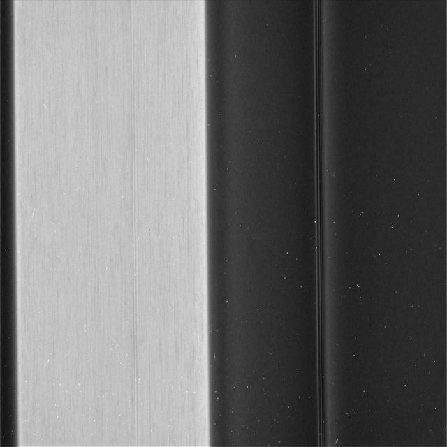 Recent images of features in Saturn's C ring called "plateaus" have deepened the mystery surrounding them. It turns out that these bright bands have a streaky texture that is very different from the textures of the regions around them.   The central feature in this image, called Plateau P5, is found approximately 52,700 miles (84,800 kilometers) from Saturn's center. It is situated amid some undulating structure that characterizes this region of the C ring. None of this structure is well understood.  This image reveals that the plateau itself is shot through with elongated streaks. This provides information about ways in which the ring particles are interacting with each other, though scientists have not yet worked out what it all means. A more clumpy texture, similar to the "straw" seen previously in the A ring.  Plateau regions are brighter than their surroundings, and have sharp edges. Recent evidence indicates that the plateaus do not actually contain more material than their surroundings, nor are they different in their chemical composition, which would mean that their greater brightness is likely due to smaller particle sizes. (If a given amount of mass is broken into smaller particles, it will spread out more [i.e., it will have more surface area].) These texture differences may give a clue about processes at the particle level that create the larger structures that Cassini has observed from greater distance throughout its mission at Saturn.  These images were taken with the camera moving in sync with the orbits of individual ring particles. Therefore, any elongated structures are truly there in the rings, and are not an artifact of particles moving during the exposure (i.e., smear).  This image was taken on the unilluminated side of the rings, with sunlight filtering through the rings as it would through a translucent bathroom window. Brighter regions in the image indicate more material scattering light toward the camera.  This image was taken on May 29, 2017, with the Cassini spacecraft narrow-angle camera. The image was acquired on the sunlit side of the rings from a distance of about 39,800 miles (64,100 kilometers) away from the area pictured. The image scale is 1,460 feet (445 meters) per pixel. The phase angle, or sun-ring-spacecraft angle, is 137 degrees.   https://photojournal.jpl.nasa.gov/catalog/PIA21619