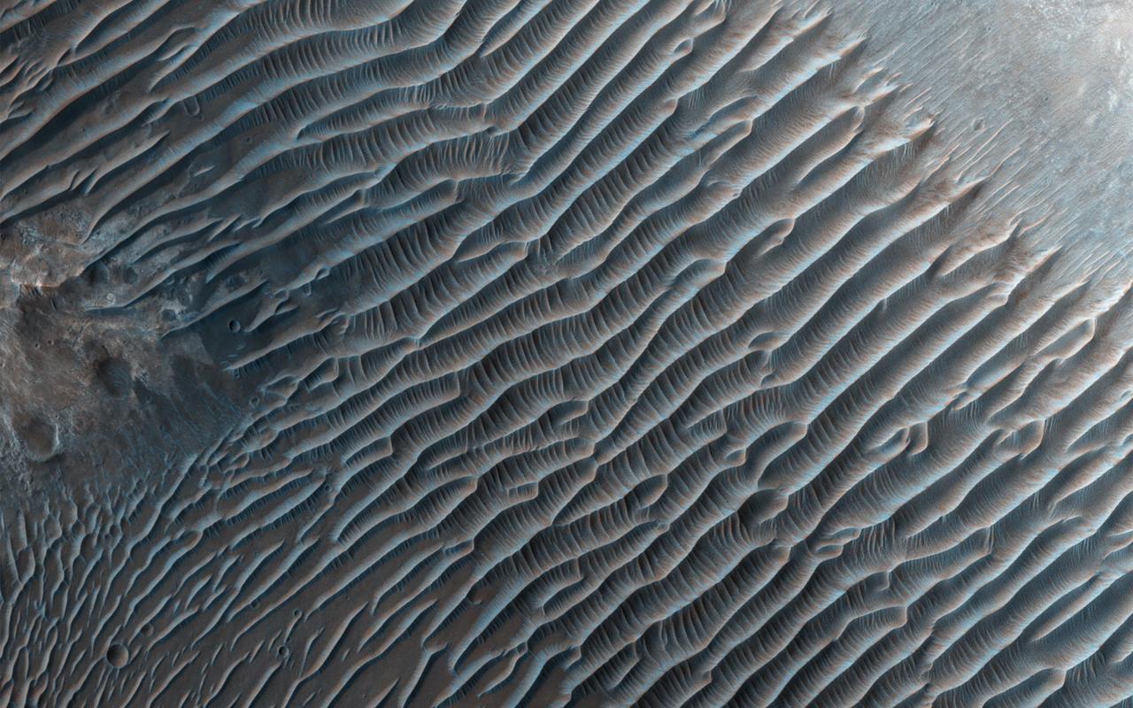 This image from NASA's Mars Reconnaissance Orbiter shows small ripples, about 10 meters apart, located in Her Desher Vallis. Her Desher is a small channel that shows evidence of phyllosilicates -- silicates with a sheet-like structure, such as clay minerals.  Much larger images of this area show that Her Desher Vallis appears isolated, with no obvious connections to craters or larger valleys. Her Desher, the ancient Egyptian name for Mars, translates to "the Red One."  https://photojournal.jpl.nasa.gov/catalog/PIA21639