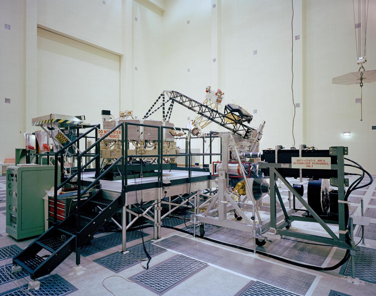 This archival photo shows the system test configuration for Voyager on October 1, 1976. The spacecraft's 10-sided bus is visible behind the catwalk railing in the foreground. The boom that holds several of the spacecraft's science instruments arches above the railing.  https://photojournal.jpl.nasa.gov/catalog/PIA21729