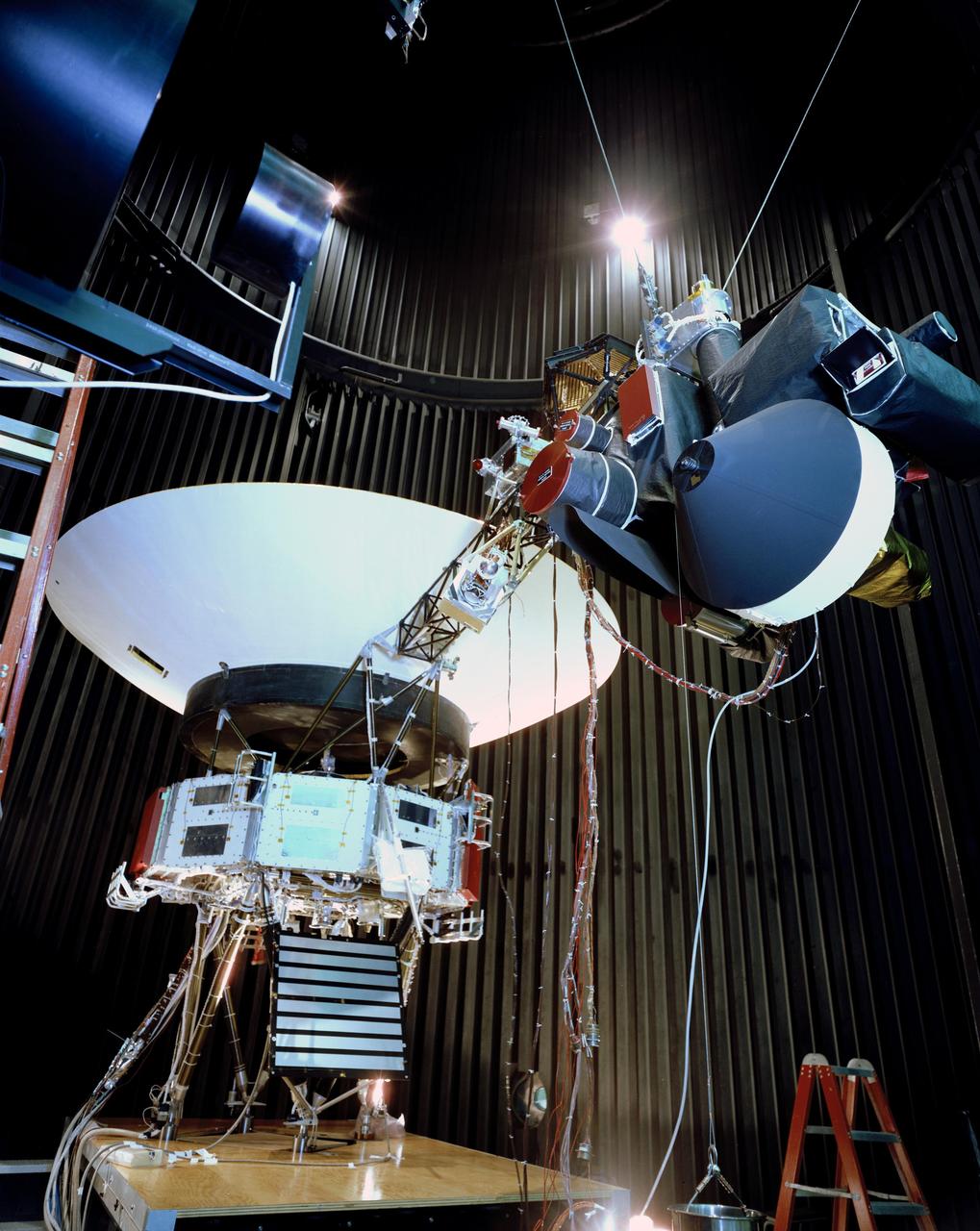 This archival photo shows the Voyager proof test model, which did not fly in space, in the 25-foot space simulator chamber at NASA's Jet Propulsion Laboratory, Pasadena, California, on December 3, 1976. The spacecraft is seen here with its scan platform, which holds several of its science instruments, in the deployed position. https://photojournal.jpl.nasa.gov/catalog/PIA21734