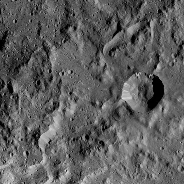 This image taken by NASA's Dawn spacecraft shows a region located next to the northwestern rim of Urvara Crater on Ceres. This terrain displays a rugged texture also found within Urvara. Multiple Dawn observations, in particular neutron spectroscopy (which measures the hydrogen content in the regolith) and flow features, have shown that water ice is present near the surface above 40 degrees north latitude, where these features are found. Therefore, the rugged texture may result from the high strength exhibited by ice at the temperatures found at mid- and high latitudes on Ceres. The prominent crater (5.0 miles, 8.8 kilometers in diameter) at right in this picture is called Tawals. Its sharp rim suggests it was created by a relatively recent impact into a relatively strong material. A different view of this crater can be found in PIA20941. Tawals Crater is named after the Polish god of the fields and the tilling. Dawn took this image during its extended mission on August 25, 2016, from its low-altitude mapping orbit, or LAMO, at a distance of about 240 miles (385 kilometers) above the surface. The center coordinates of this image are 40 degrees south latitude, 237 degrees east longitude. https://photojournal.jpl.nasa.gov/catalog/PIA21750