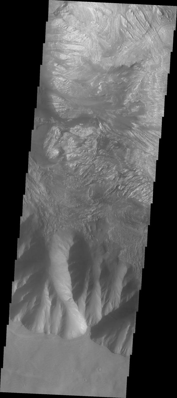 This image shows the part of the southern cliff face of Hebes Chasma at the bottom of the image. The materials seen in the majority of this image are part of the erosion of the central mesa, perhaps created by a massive landslide. Hebes Chasma is an enclosed basin not connected to Valles Marineris.  The Odyssey spacecraft has spent over 15 years in orbit around Mars, circling the planet more than 69000 times. It holds the record for longest working spacecraft at Mars. THEMIS, the IR/VIS camera system, has collected data for the entire mission and provides images covering all seasons and lighting conditions. Over the years many features of interest have received repeated imaging, building up a suite of images covering the entire feature. From the deepest chasma to the tallest volcano, individual dunes inside craters and dune fields that encircle the north pole, channels carved by water and lava, and a variety of other feature, THEMIS has imaged them all. For the next several months the image of the day will focus on the Tharsis volcanoes, the various chasmata of Valles Marineris, and the major dunes fields. We hope you enjoy these images!  Orbit Number: 10701 Latitude: -1.17496 Longitude: 282.347 Instrument: VIS Captured: 2004-05-13 10:46  https://photojournal.jpl.nasa.gov/catalog/PIA21810