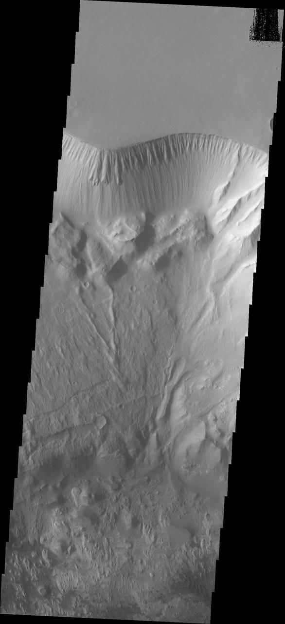 This image shows the north central cliff face of Hebes Chasma. The cliff face and downslope movement of material is very different in appearance than the same features of the large mesa in the center of the chasma. Hebes Chasma is an enclosed basin not connected to Valles Marineris.  The Odyssey spacecraft has spent over 15 years in orbit around Mars, circling the planet more than 69000 times. It holds the record for longest working spacecraft at Mars. THEMIS, the IR/VIS camera system, has collected data for the entire mission and provides images covering all seasons and lighting conditions. Over the years many features of interest have received repeated imaging, building up a suite of images covering the entire feature. From the deepest chasma to the tallest volcano, individual dunes inside craters and dune fields that encircle the north pole, channels carved by water and lava, and a variety of other feature, THEMIS has imaged them all. For the next several months the image of the day will focus on the Tharsis volcanoes, the various chasmata of Valles Marineris, and the major dunes fields. We hope you enjoy these images!  Orbit Number: 26886 Latitude: -0.142089 Longitude: 283.512 Instrument: VIS Captured: 2008-01-06 02:43  https://photojournal.jpl.nasa.gov/catalog/PIA21814