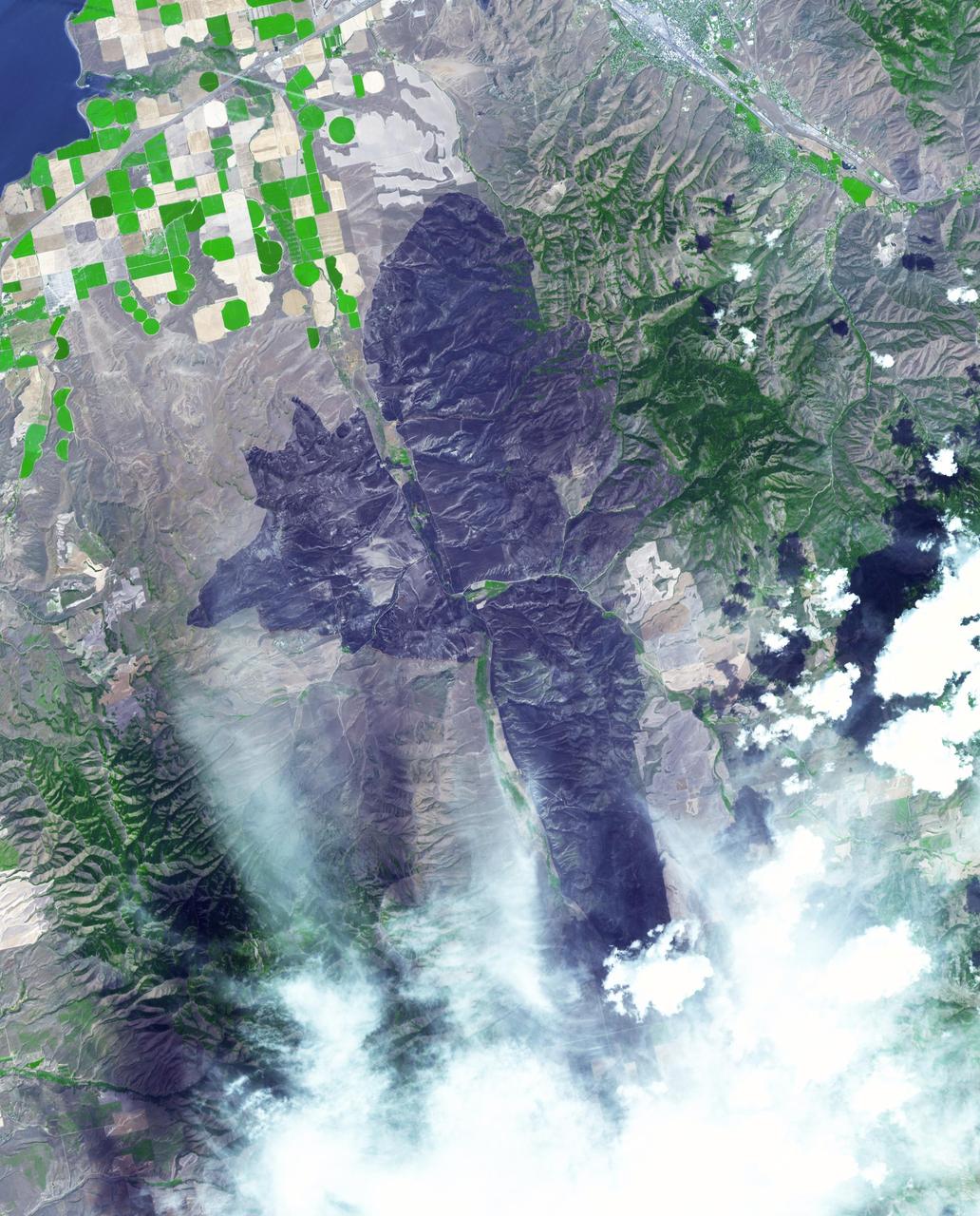 A wildfire burned 46,000 acres southwest of Pocatello, Idaho, threatening homes and filling the area with smoke. The human-caused fire was 85 percent contained by Aug. 10, 2017. The extent of the burned area is evident in this image as the dark gray area. The image was acquired Aug. 13, 2017, covers an area of 22 by 28 miles (36 by 45 kilometers), and is located at 42.7 degrees north, 112.6 degrees west.  https://photojournal.jpl.nasa.gov/catalog/PIA21875