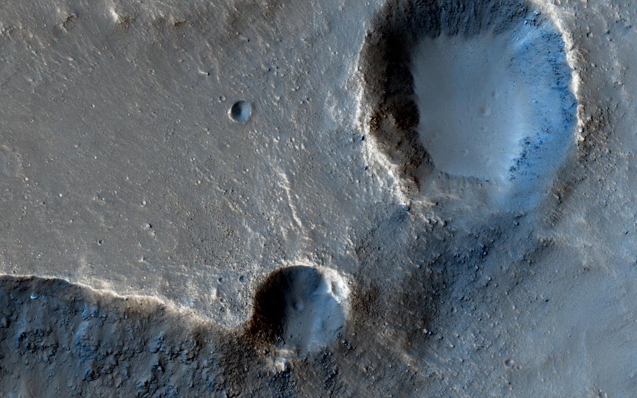 In this observation from NASA's Mars Reconnaissance Orbiter, these two craters perched at the edge of an outflow channel, appear to have lost a portion of their crater rims during a flood event.  Alternatively, it is also possible that the craters impacted the edge of the outflow channel after the flood occurred and we are seeing the difference in the strength of the material impacted.   https://photojournal.jpl.nasa.gov/catalog/PIA21881