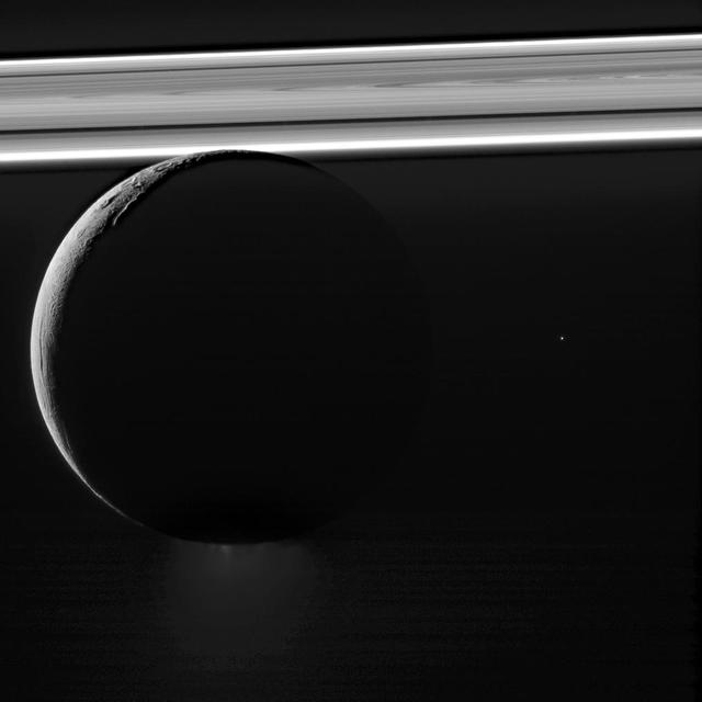 Saturn's moon Enceladus drifts before the rings, which glow brightly in the sunlight. Beneath its icy exterior shell, Enceladus hides a global ocean of liquid water. Just visible at the moon's south pole (at bottom here) is the plume of water ice particles and other material that constantly spews from that ocean via fractures in the ice. The bright speck to the right of Enceladus is a distant star. This image was taken in visible light with the Cassini spacecraft narrow-angle camera on Nov. 6, 2011, at a distance of approximately 90,000 miles (145,000 kilometers) from Enceladus. The Cassini spacecraft ended its mission on Sept. 15, 2017. https://photojournal.jpl.nasa.gov/catalog/PIA21900