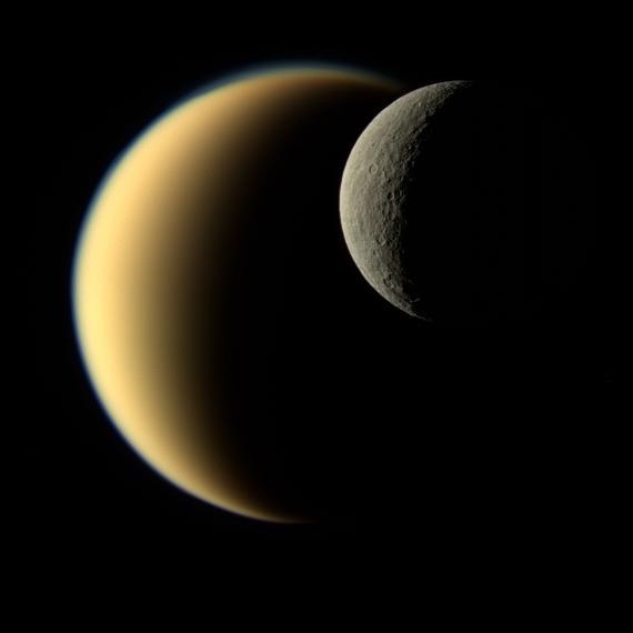 In this view, Saturn's icy moon Rhea passes in front of Titan as seen by NASA's Cassini spacecraft. Some of the differences between the two large moons are readily apparent. While Rhea is a heavily-cratered, airless world, Titan's nitrogen-rich atmosphere is even thicker than Earth's.  This natural color image was taken in visible light with the Cassini narrow-angle camera on Nov. 19, 2009, at a distance of approximately 713,300 miles (1,148,000 kilometers) from Rhea.  The Cassini spacecraft ended its mission on Sept. 15, 2017.  https://photojournal.jpl.nasa.gov/catalog/PIA21904