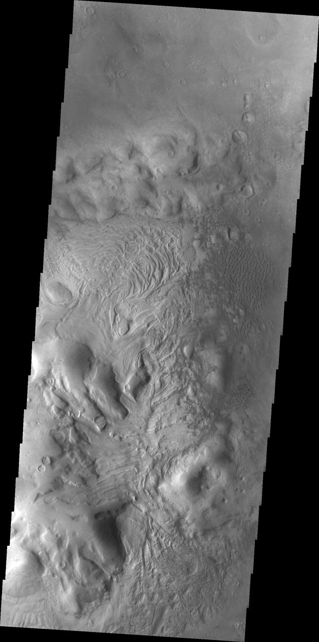 This image of Moreux Crater is dominated by the central peak. There are sand dunes on the right side of the image. The part of the peak with a pitted surface texture and curvilinear ridges has been interpreted to be created by glacial flows. Moreux Crater is located in northern Arabia Terra and has a diameter of 138 kilometers.  The Odyssey spacecraft has spent over 15 years in orbit around Mars, circling the planet more than 69000 times. It holds the record for longest working spacecraft at Mars. THEMIS, the IR/VIS camera system, has collected data for the entire mission and provides images covering all seasons and lighting conditions. Over the years many features of interest have received repeated imaging, building up a suite of images covering the entire feature. From the deepest chasma to the tallest volcano, individual dunes inside craters and dune fields that encircle the north pole, channels carved by water and lava, and a variety of other feature, THEMIS has imaged them all. For the next several months the image of the day will focus on the Tharsis volcanoes, the various chasmata of Valles Marineris, and the major dunes fields. We hope you enjoy these images!  Orbit Number: 38224 Latitude: 41.9222 Longitude: 44.698 Instrument: VIS Captured: 2010-07-27 16:53  https://photojournal.jpl.nasa.gov/catalog/PIA22032