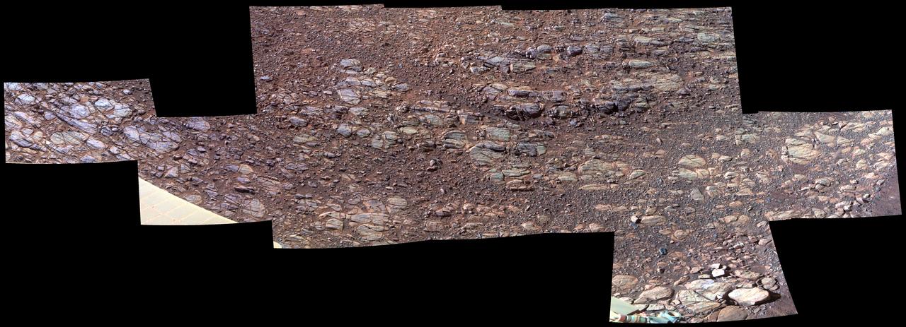 This patch of rocky Martian ground on the floor of "Perseverance Valley" on the inner slope of the western rim of Endurance Crater slopes steeply downhill from left to right. Some textures seen here, including striations just above and parallel to the edge of a solar panel at far left, may be due to abrasion by wind-driven sand. Researchers interpret them as possible signs of past winds blowing from right to left, up and out of the crater, which currently hosts sand dunes on its central floor.  The view spans about 11.5 feet (3.5 meters) from left to right and is presented in enhanced color to make differences in surface materials easier to see. The Panoramic Camera (Pancam) on NASA's Mars Exploration Rover Opportunity took the component images of this scene during the period Oct. 13 through Oct. 20, 2017, corresponding to sols (Martian days) 4878 through 4884 of the rover's work on Mars.  Opportunity entered the upper end of Perseverance Valley in July 2017 for several months of investigating how it formed. The valley is a system of shallow troughs extending about the length of two football fields down the crater rim's steep inner slope. Endurance Crater is about 14 miles (22 kilometers) in diameter. Opportunity has been exploring features on its western rim since 2011, after investigating a series of smaller craters beginning with the one it landed in on Jan. 25, 2004, Universal Time (Jan. 24, PST).  The origin of Perseverance Valley is unknown, but some observed features suggest that water might have played a role in the past. Opportunity is descending the steep valley, making observations along the way that could help illuminate the origin of this feature.  The bedrock target area in this view is called "La Bajada." The image combines exposures taken through three Pancam filters, centered at wavelengths of 753 nanometers (near-infrared), 535 nanometers (green) and 432 nanometers (violet).  https://photojournal.jpl.nasa.gov/catalog/PIA22072