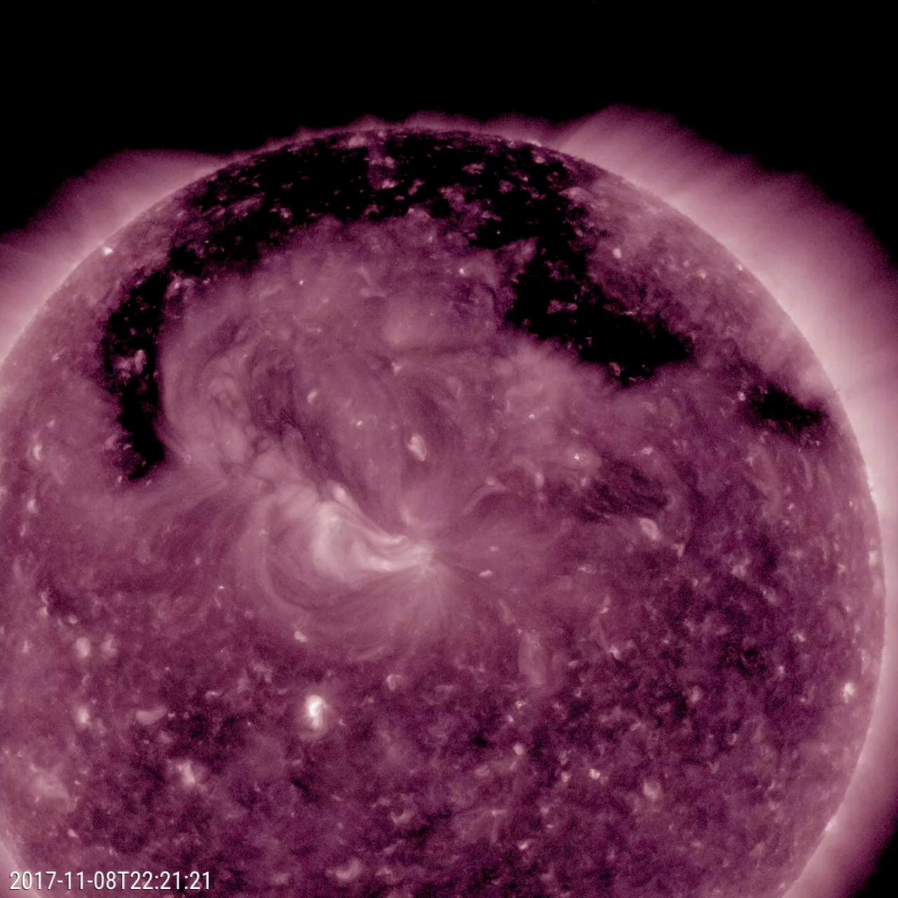 This image from NASA's Solar Dynamics Observatory shows a broad coronal hole was the dominant feature this week on the sun (Nov. 7-9, 2017). It was easily recognizable as the dark expanse across the top of the sun and extending down in each side. Coronal holes are magnetically open areas on the sun that allow high-speed solar wind to gush out into space. They always appear darker in extreme ultraviolet. This one was likely the source of bright aurora that shimmered for numerous observers, with some reaching down even to Nebraska.  Movies are available at https://photojournal.jpl.nasa.gov/catalog/PIA22113