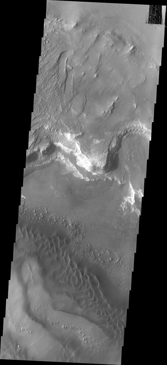 Melas Chasma is part of the largest canyon system on Mars, Valles Marineris. At only 563 km long (349 miles) it is not the longest canyon, but it is the widest. Located in the center of Valles Marineris, it has depths up to 9 km below the surrounding plains, and is the location of many large landslide deposits, as will as layered materials and sand dunes. There is evidence of both water and wind action as modes of formation for many of the interior deposits. Today's image of the southern section of the canyon shows a large region of sand dunes. The presence of dunes indicates wind action as the most recent geologic process modifying the canyon.  The Odyssey spacecraft has spent over 15 years in orbit around Mars, circling the planet more than 69000 times. It holds the record for longest working spacecraft at Mars. THEMIS, the IR/VIS camera system, has collected data for the entire mission and provides images covering all seasons and lighting conditions. Over the years many features of interest have received repeated imaging, building up a suite of images covering the entire feature. From the deepest chasma to the tallest volcano, individual dunes inside craters and dune fields that encircle the north pole, channels carved by water and lava, and a variety of other feature, THEMIS has imaged them all. For the next several months the image of the day will focus on the Tharsis volcanoes, the various chasmata of Valles Marineris, and the major dunes fields. We hope you enjoy these images!  Orbit Number: 18513 Latitude: -12.752 Longitude: 288.597 Instrument: VIS Captured: 2006-02-15 15:24  https://photojournal.jpl.nasa.gov/catalog/PIA22131