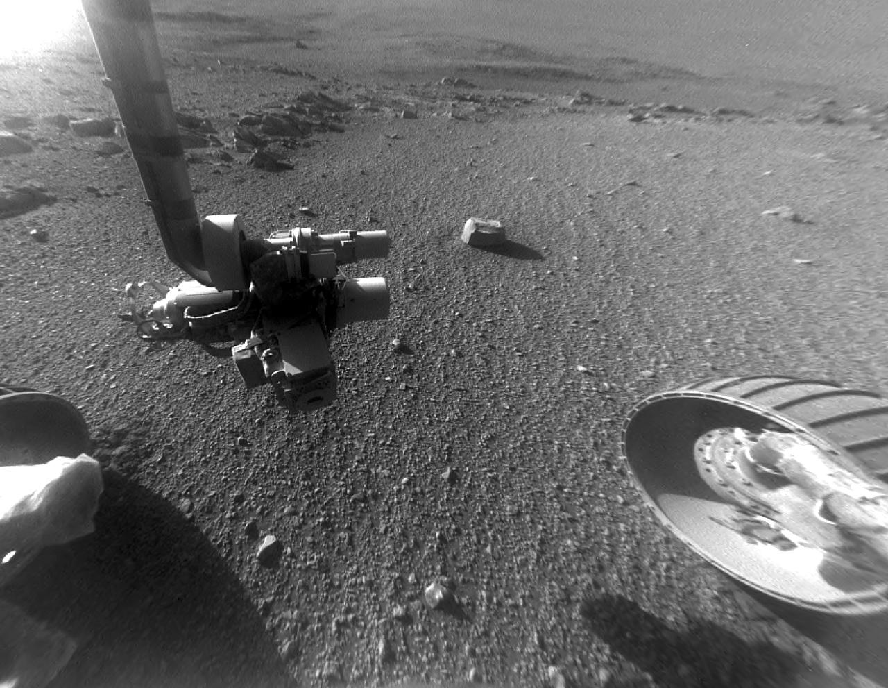 This late-afternoon view from the front Hazard Avoidance Camera on NASA's Mars Exploration Rover Opportunity shows a pattern of rock stripes on the ground, a surprise to scientists on the rover team. Approaching the 5,000th Martian day or sol, of what was planned as a 90-sol mission, Opportunity is still providing new discoveries. This image was taken inside "Perseverance Valley," on the inboard slope of the western rim of Endeavour Crater, on Sol 4958 (Jan. 4, 2018). Both this view and one taken the same sol by the rover's Navigation Camera look downhill toward the northeast from about one-third of the way down the valley, which extends about the length of two football fields from the crest of the rim toward the crater floor. The lighting, with the Sun at a low angle, emphasizes the ground texture, shaped into stripes defined by rock fragments. The stripes are aligned with the downhill direction. The rock to the upper right of the rover's robotic arm is about 2 inches (5 centimeters) wide and about 3 feet (1 meter) from the centerline of the rover's two front wheels. This striped pattern resembles features seen on Earth, including on Hawaii's Mauna Kea, that are formed by cycles of freezing and thawing of ground moistened by melting ice or snow. There, fine-grained fraction of the soil expands as it freezes, and this lifts the rock fragments up and to the sides. If such a process formed this pattern in Perseverance Valley, those conditions might have been present locally during a period within the past few million years when Mars' spin axis was at a greater tilt than it is now, and some of the water ice now at the poles was redistributed to lower latitudes. Other hypotheses for how these features formed are also under consideration, including high-velocity slope winds. https://photojournal.jpl.nasa.gov/catalog/PIA22218