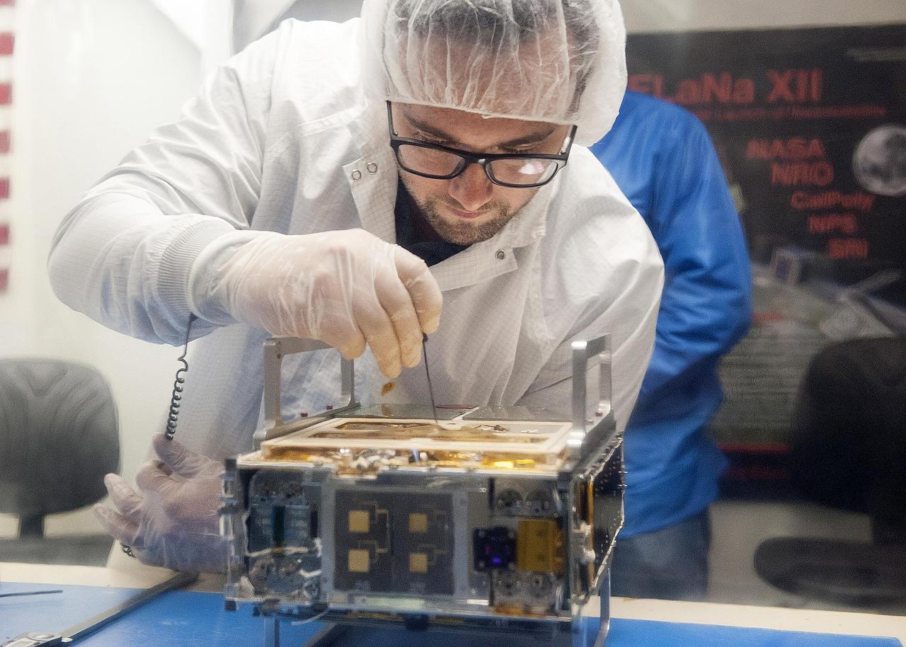 Joel Steinkraus, MarCO lead mechanical engineer from JPL, makes an adjustment on the CubeSat prior to integration in a deployment box as seen inside the cleanroom lab at Cal Poly San Luis Obispo on Monday, March 12, 2018.  https://photojournal.jpl.nasa.gov/catalog/PIA22321