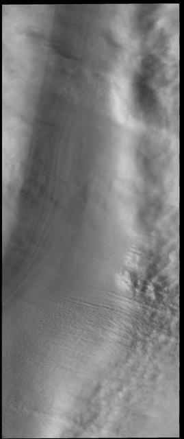 This VIS image shows 'streamers' of clouds created by katabatic winds at the north polar cap. Katabatic winds are created by cold air sinking at the pole and then speeding along the ice surface towards the edge of the polar cap. When the winds enter troughs the wind regime changes from laminar flow to choatic and clouds of ice particles and/or dust are visible. This wind activity peaks at the start of northern hemisphere summer. Orbit Number: 53942 Latitude: 86.8433 Longitude: 99.3149 Instrument: VIS Captured: 2014-02-10 10:50 https://photojournal.jpl.nasa.gov/catalog/PIA22362