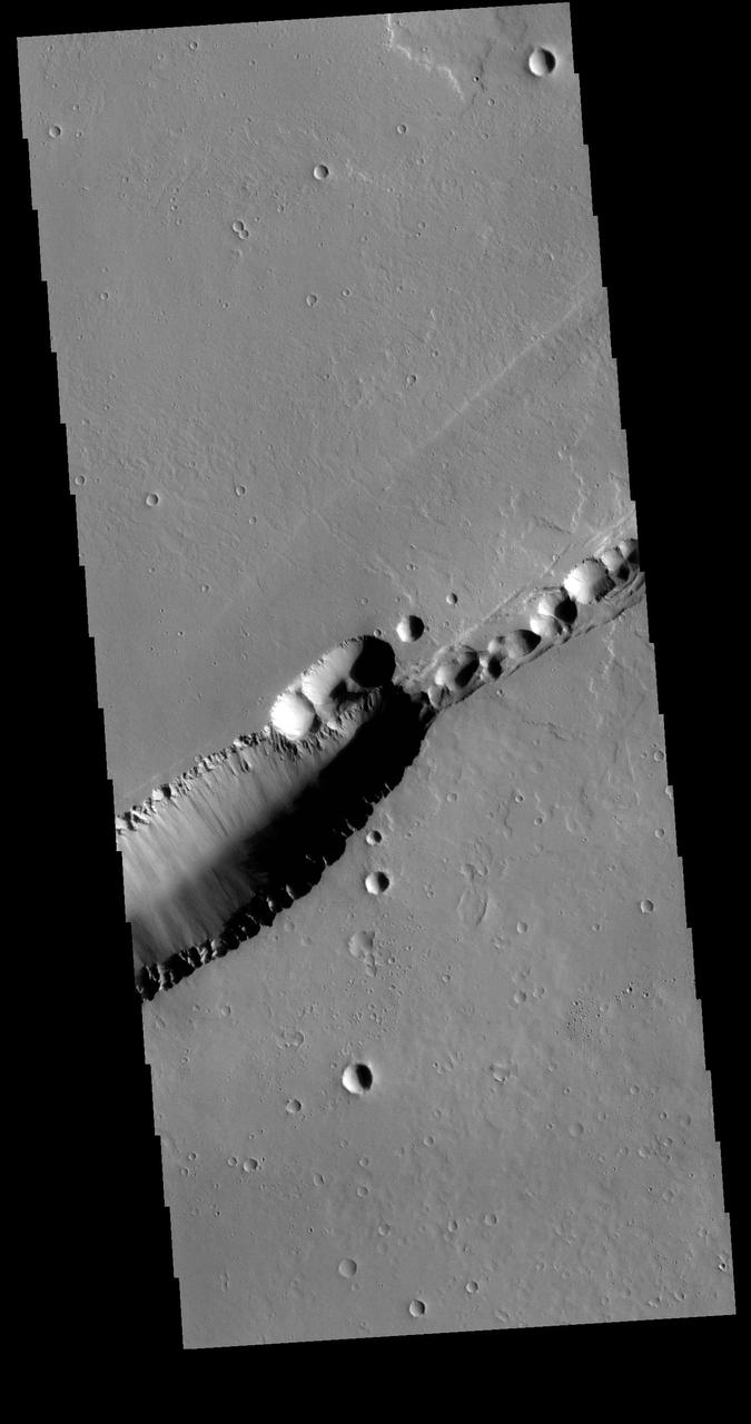 The feature that crosses this VIS image is a graben. Graben are formed by tectonic action, where a block of material moves downward between a pair of faults. The northern part of the Tharsis plateau is full of graben, most notably surrounding Alba Mons. The section of Labeatis Fossae seen in this image is directly south of Uranius Mons. Orbit Number: 71332 Latitude: 23.3233 Longitude: 267.467 Instrument: VIS Captured: 2018-01-12 15:07 https://photojournal.jpl.nasa.gov/catalog/PIA22387
