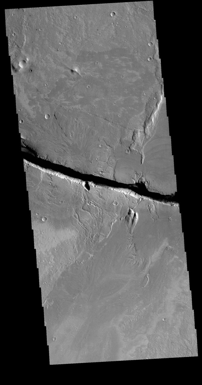 This VIS image shows a section of Cerberus Fossae. Located southeast of the Elysium Planitia volcanic complex, the linear graben was created by tectonic forces related to the volcanic activity. The fossae cuts across features such as hills, indicating the relative youth of the tectonic activity. The fossae is also the source of several channels, some of which are visible on the bottom of the fossae. Orbit Number: 71498 Latitude: 9.94964 Longitude: 157.873 Instrument: VIS Captured: 2018-01-26 07:16 https://photojournal.jpl.nasa.gov/catalog/PIA22397