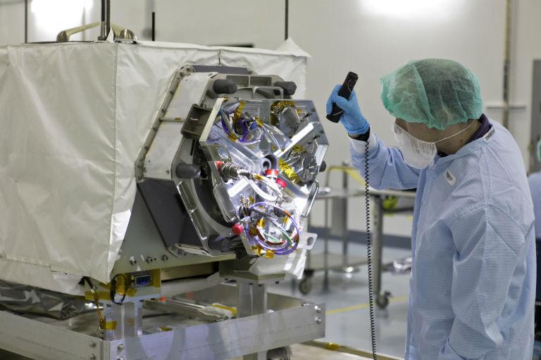 A technician inspects NASA's ECOSTRESS instrument in a clean room at Kennedy Space Center in Florida. ECOSTRESS measures the temperature of plants, which shows how they are regulating their water use in response to heat stress.  https://photojournal.jpl.nasa.gov/catalog/PIA22509
