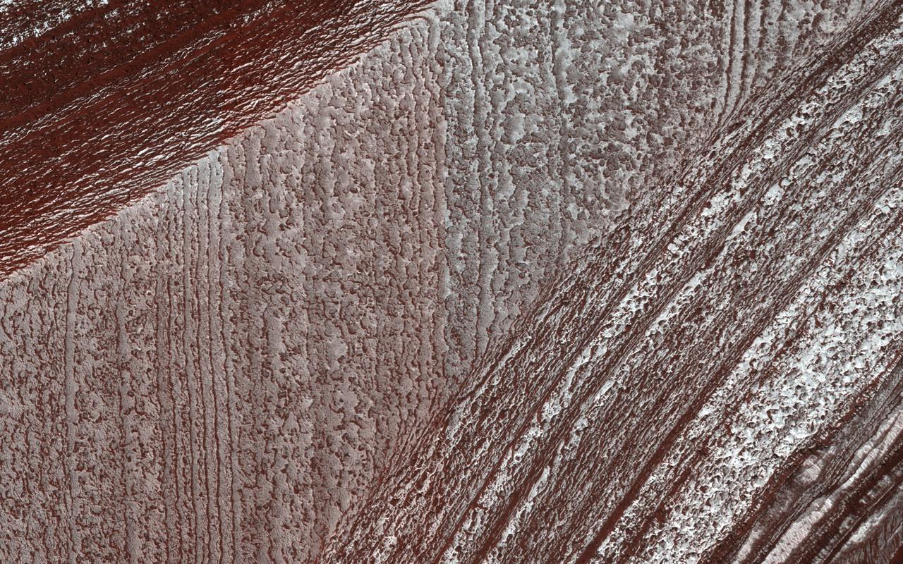 Mars' north polar layered deposits comprise a thick stack of icy layers. Part of this image from NASA's Mars Reconnaissance Orbiter (MRO) has lingering seasonal frost, which serves to accentuate those layers. An additional rationale for this observation is to document new activity in scarp erosion. More information is available at https://photojournal.jpl.nasa.gov/catalog/PIA22533