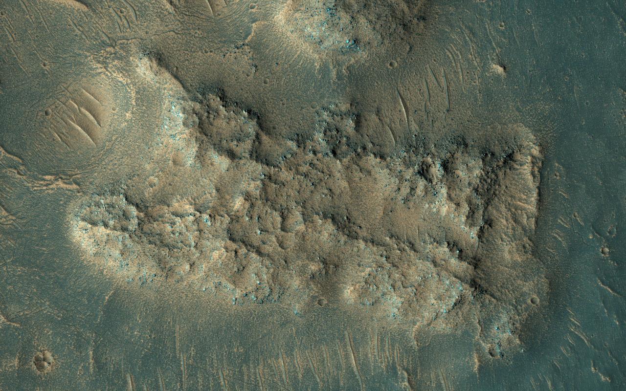 This image was acquired on May 13, 2018 by NASA's Mars Reconnaissance Orbiter. A hotspot for exploration on Mars centers on areas that were once, or are currently, next to a significant source of heat such as volcanoes. Martian volcanoes have not been active for the last couple million years, but beneath the shifting sands and dust of the Red Planet we find old lava flows frozen in time. These ancient lava flows may have provided a source of heat, along with liquid water or subsurface ice, to generate an environment conducive for the development of ancient life. Geological evidence for hot water interacting with rock is what we mean by hydrothermal: sites with these conditions are very difficult to identify from orbit. One closeup view shows sand dunes scouring what appears to be a highly-cratered, old lava flow in the Tempe Terra region, located in the Northern Hemisphere. The flat, dark areas are basaltic in composition, a rock commonly found around active volcanoes, and the lighter-toned material is covered in rusted Martian dust. The recently-launched InSight lander will reveal whether Mars is geologically active internally. More information is available at https://photojournal.jpl.nasa.gov/catalog/PIA22586