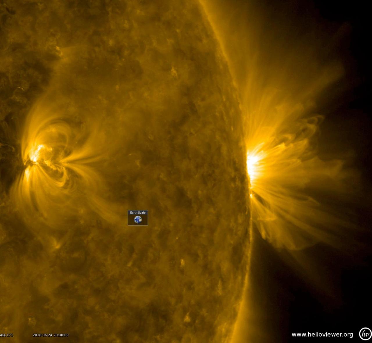 This profile perspective of an active region revealed above it (June 24-25, 2018). Charged particles spinning along these field lines are illuminated in this wavelength of extreme ultraviolet light. The little Earth superimposed on the image and videos gives one a sense of just how humongous these loops really are. Our eyes cannot see extreme ultraviolet light, but our instruments can. The images are colorized to distinguish between these from images taken in other wavelengths by SDO. Note there is another, smaller active region on the left side of the image. Movies are available at https://photojournal.jpl.nasa.gov/catalog/PIA22589