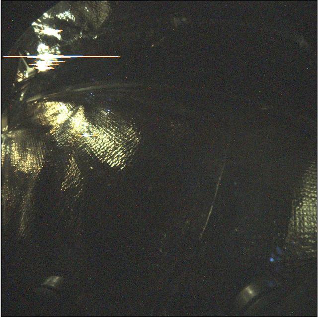 This long-exposure image (24 seconds) was taken by Instrument Context Camera (ICC) of NASA's InSight Mars lander. The image shows some of the interior features of the backshell that encapsulates the spacecraft. The backshell carries the parachute and several components used during later stages of entry, descent, and landing. Along with the heatshield, the backshell protects NASA's InSight Mars lander during its commute to and entry into the Martian atmosphere.  The annotations in this image call out discernable components in the backshell -- the heatshield blanket, harness tie-downs, and cover bolts for the ICC. The heat shield blanket provides thermal protection from the hot and cold temperature swings encountered during cruise, and the high heat that will occur during Mars atmospheric entry. The tie-downs are used to secure harnesses (or other objects) so they do not move around inside the aeroshell while in flight. The ICC cover bolts secure a protective transparent window to the camera during cruise and entry, descent and landing. The cover is opened after landing and is not visible during surface operations.  This image has been stretched to bring out details in the dimly lit scene. The illumination of the components on the inside of the backshell comes from sunlight entering around the edges of cutouts in the backshell to accommodate steering thrusters.   An annotated image is available at https://photojournal.jpl.nasa.gov/catalog/PIA22647