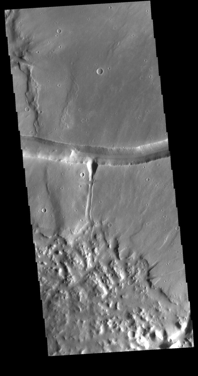 The right angle intersection of the depressions in this VIS image is one of the graben that form Sacra Fossae. The fossae are located on Sacra Mensa, near the beginning of Kasei Valles. Graben are depressions caused by parallel faults where a block of material drops down along the fault face. Orbit Number: 72803 Latitude: 23.2339 Longitude: 290.007 Instrument: VIS Captured: 2018-05-13 19:26 https://photojournal.jpl.nasa.gov/catalog/PIA22657