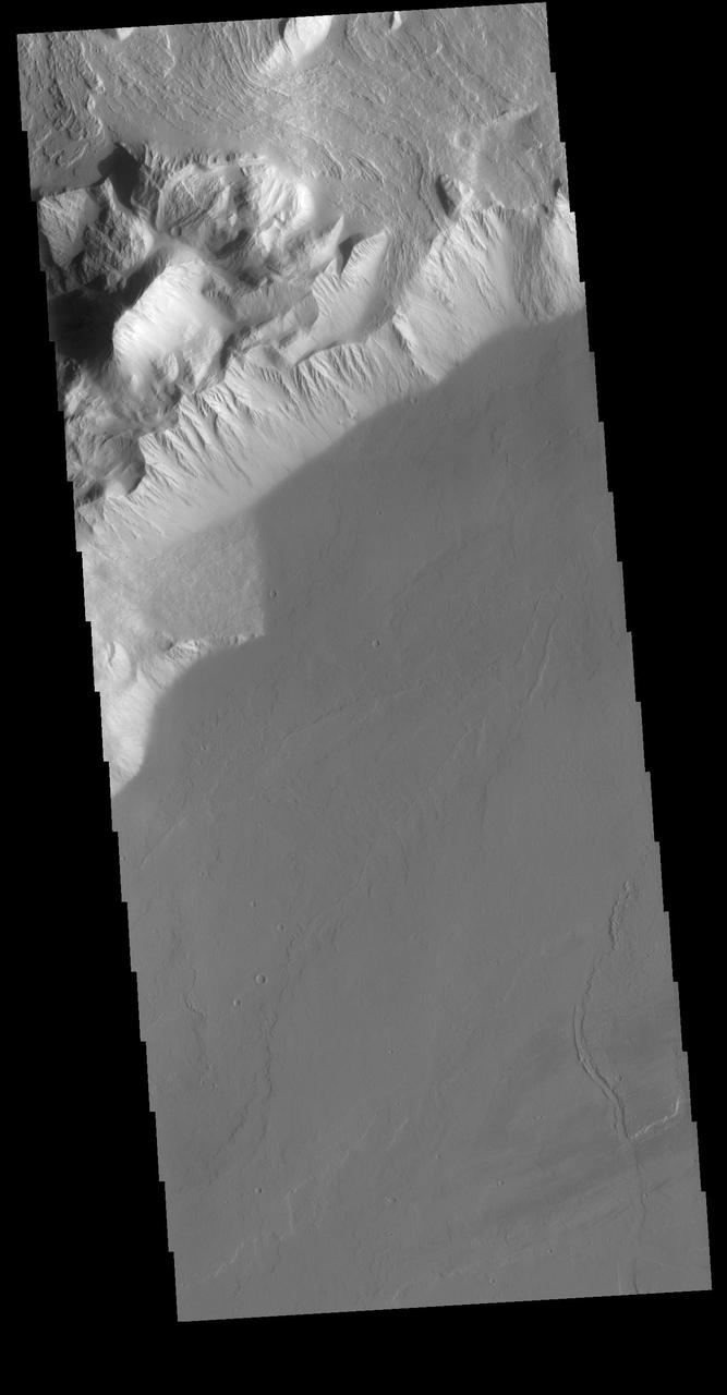 Olympus Rupes is the name of the large escarpment surrounding Olympus Mons. The escarpment is a cliff where there is a large elevation change over a short distance. The elevation change from the lower volcanic plains to the volcano flank is up to 5 miles (26,400 feet), almost the height of Mount Everest. This VIS image is located along the southeastern margin of Olympus Mons, the largest Martian volcano. Orbit Number: 72880 Latitude: 13.9993 Longitude: 228.976 Instrument: VIS Captured: 2018-05-20 03:37 https://photojournal.jpl.nasa.gov/catalog/PIA22659