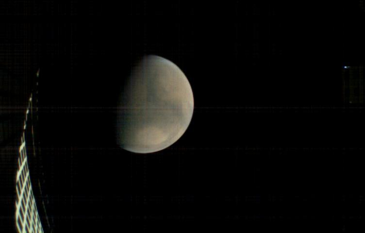 MarCO-B, one of the experimental Mars Cube One (MarCO) CubeSats, took this image of Mars from about 11,300 miles (18,200 kilometers) away shortly before NASA's InSight spacecraft landed on Mars on Nov. 26, 2018. MarCO-B flew by Mars with its twin, MarCO-A, to serve as communications relays for InSight spacecraft as it touched down around noon PST (3 p.m. EST). This image was taken at 10:35 a.m. PST (1:35 p.m. EST).  Mars' north pole is at the top. A lighter-toned circular feature known as Hellas Basin is visible in the southern hemisphere. MarCO-B's antenna reflector can be seen at left. The blue dot on the right is a glint of sunlight off the antenna feed (not visible in the picture).  https://photojournal.jpl.nasa.gov/catalog/PIA22831