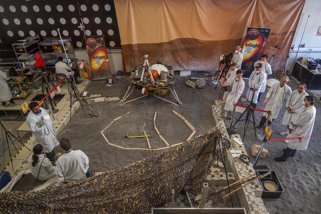 Engineers in Pasadena, California, sculpt a gravel-like material to mimic the terrain in front of NASA's InSight lander on Mars. Recreating the exact conditions will allow them to practice setting down the lander's instruments here on Earth (at NASA's Jet Propulsion Laboratory) before it's done on Mars. https://photojournal.jpl.nasa.gov/catalog/PIA22879