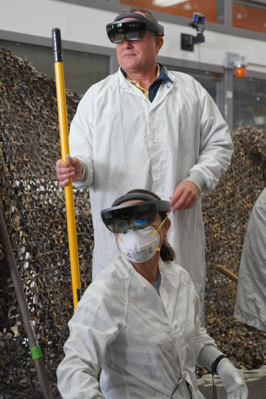 InSight Project Manager Tom Hoffman (standing) and engineer Marleen Sundgaard wear Microsoft HoloLens augmented reality headsets, which project digital terrain models of InSight's landing location on Mars over a lab space.  https://photojournal.jpl.nasa.gov/catalog/PIA22951