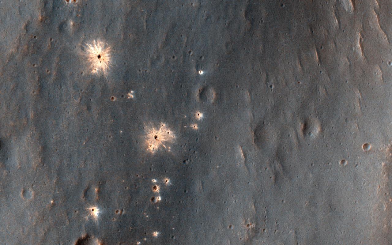 This image shows a recent impact in Noachis Terra in the southern mid-latitudes of Mars. The impact occurred in dark-toned ejecta material from a degraded, 60-kilometer crater to the south.  Rather than a single impact crater, we see multiple impacts like a shotgun blast. This suggests that the impactor broke up in the atmosphere on entry. Although the atmosphere of Mars is thinner than Earth's, it still has the capacity to break up small impactors, especially ones comprised of weaker materials, like a stony meteoroid versus a iron-nickel one.  Our image depicts 21 distinctive craters ranging in size from 1 to 7 meters in diameter. They are distributed over an area that spans about 305 meters. Most observed recent impacts expose darker-toned materials underlying bright dusty surfaces. However, this impact does the opposite, showing us lighter-toned materials that lie beneath a darker colored surface.  The impact was initially discovered in a 2016 Context Camera image, and was not seen in a 2009 picture. This implies that the impact may be only two years old, but certainly no more than nine years.   https://photojournal.jpl.nasa.gov/catalog/PIA23061