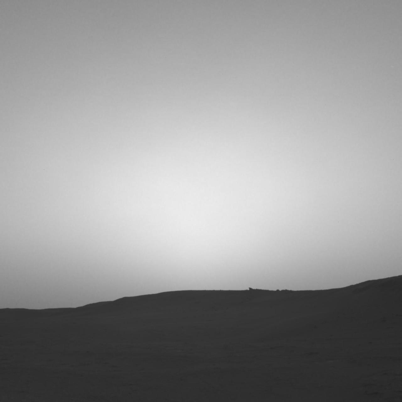 This series of images shows the shadow of Phobos as it sweeps over NASA's Curiosity Mars rover and darkens the sunlight on Monday, March 25, 2019 (the 2,358th sol, or Martian day, of the mission). This image was taken by one of Curiosity's Navigation Cameras (Navcams). The sequence has been contrast-enhanced and sped up by a factor of four. The image was taken after the Sun had descended behind the horizon, just as Phobos was rising and throwing its elongated shadow across the Martian surface. Dust particles in the atmosphere acted as a screen against which the shadow was projected. Movie available at https://photojournal.jpl.nasa.gov/catalog/PIA23135