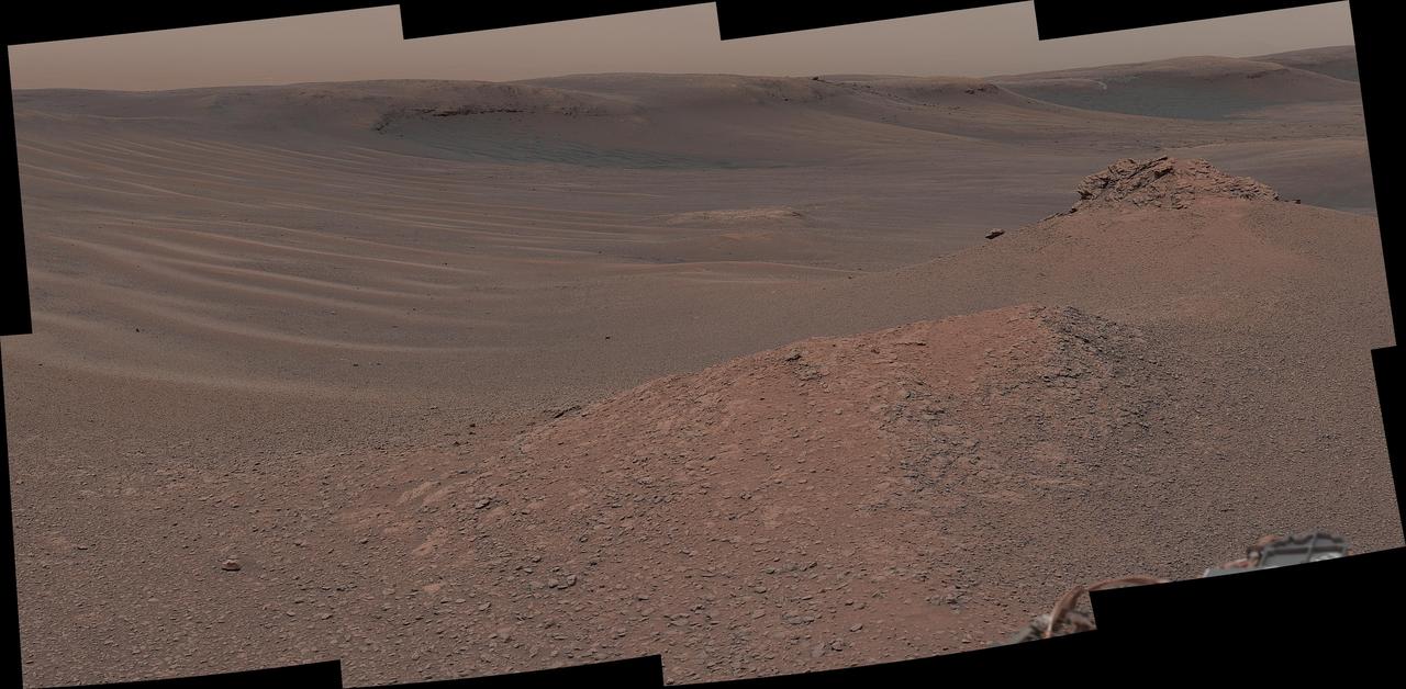 The Mast Camera (Mastcam) on NASA's Curiosity Mars rover captured this mosaic as it explored the "clay-bearing unit" on Feb. 3, 2019 (Sol 2309). This landscape includes the rocky landmark nicknamed "Knockfarril Hill" (center right) and the edge of Vera Rubin Ridge, which runs along the top of the scene.  Made of many individual images, this mosaic includes a variety of geological features, such as several kinds of bedrock and sand. The clay-bearing unit has been an important scientific destination since before Curiosity launched. NASA's Mars Reconnaissance Orbiter (MRO) spied a strong clay "signal" in this region, indicating that water may have played a role in its formation. On its long trek since landing in 2012, Curiosity has discovered many examples of mudstones containing clay minerals.  The scene is presented with a color adjustment that approximates white balancing to resemble how the rocks and sand would appear under daytime lighting conditions on Earth.  https://photojournal.jpl.nasa.gov/catalog/PIA23139