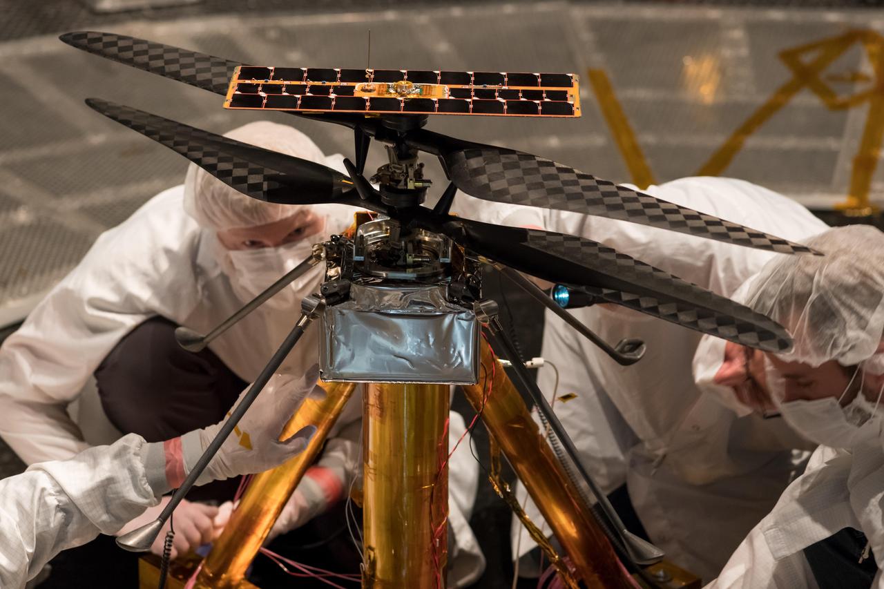 Members of the NASA Mars Helicopter team inspect the flight model (the actual vehicle going to the Red Planet), inside the Space Simulator, a 25-foot-wide (7.62-meter-wide) vacuum chamber at NASA's Jet Propulsion Laboratory in Pasadena, California, on Feb. 1, 2019.  https://photojournal.jpl.nasa.gov/catalog/PIA23155