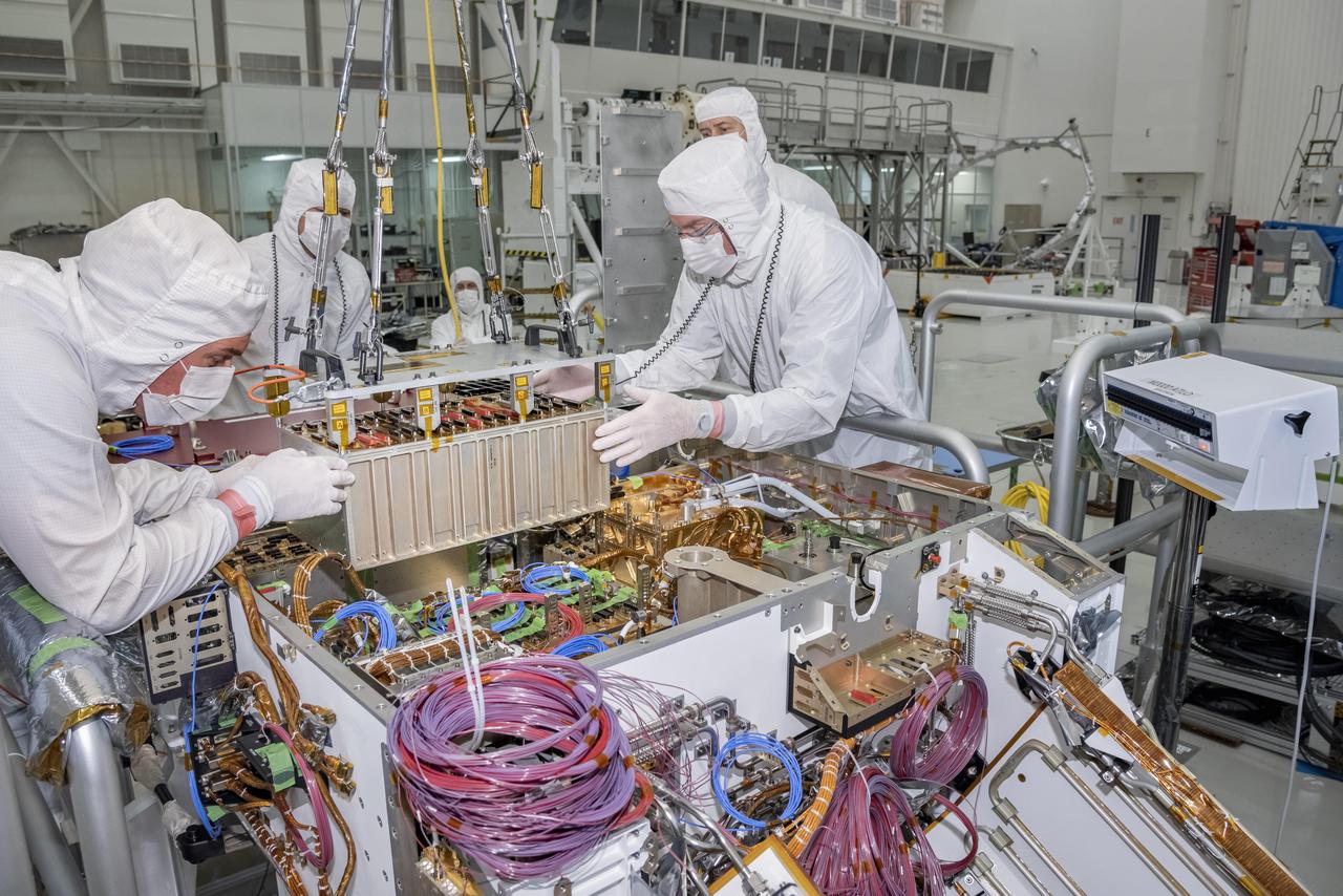 Engineers and technicians at NASA's Jet Propulsion Laboratory in Pasadena, California, integrate the rover motor controller assembly (RMCA) into the Mars 2020 rover's body. The RMCA is the electrical heart of the rover's mobility and motion systems, commanding and regulating the movement of the motors in the rover's wheels, robotic arms, mast, drill and sample-handling functions.  The image was taken on April 29, 2019, in the Spacecraft Assembly Facility's High Bay 1 clean room at JPL.  https://photojournal.jpl.nasa.gov/catalog/PIA23194