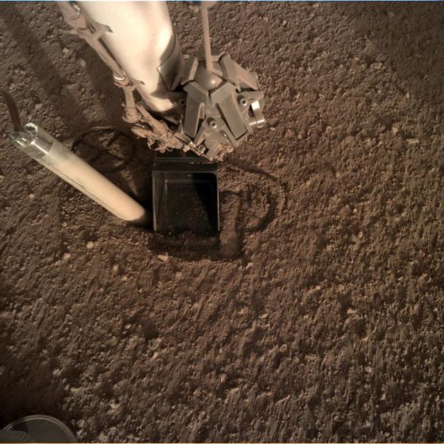 In this image from Oct. 26, 2019 — the 325th Martian day, or sol, of the mission — InSight's heat probe, or "mole," is seen after backing about halfway out of the hole it had burrowed.  Animation available at https://photojournal.jpl.nasa.gov/catalog/PIA23213