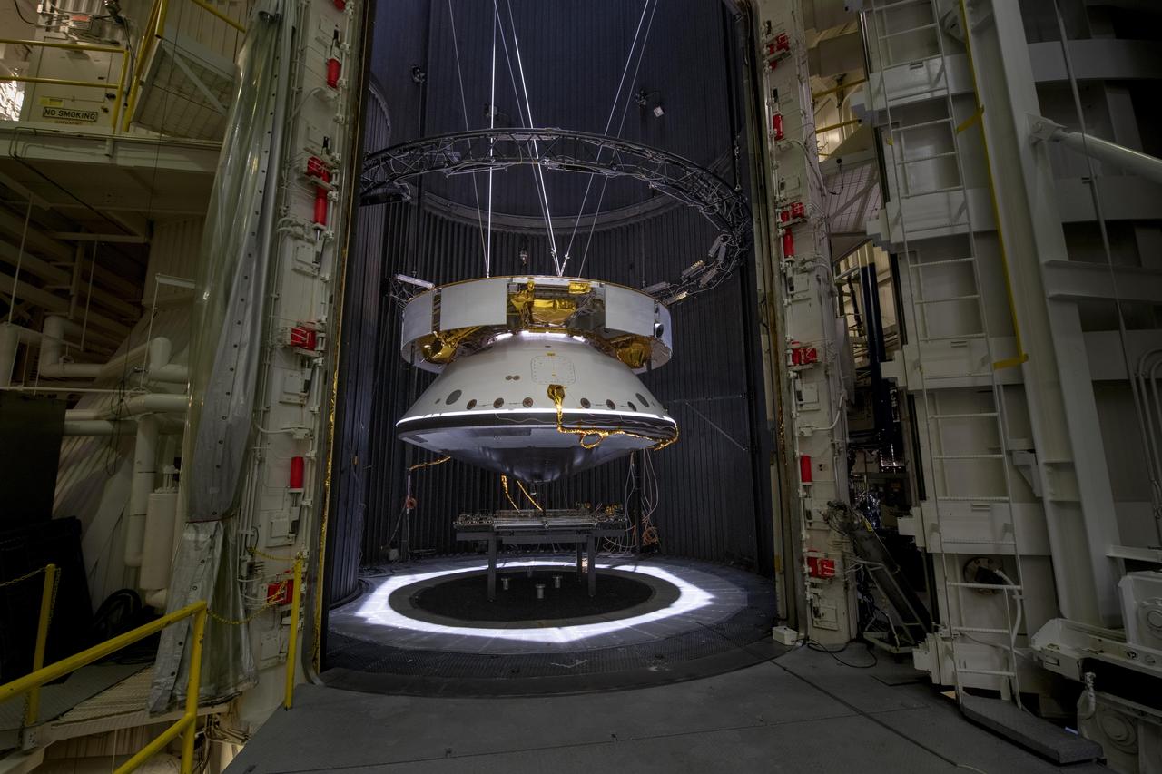 The completed spacecraft that will carry NASA's next Mars rover to the Red Planet is suspended by cables as it is prepared for thermal vacuum (TVAC) testing in the Space Simulator Facility at NASA's Jet Propulsion Laboratory in Pasadena, California.  From the top down is the complete cruise stage, which will power and guide the Mars 2020 spacecraft on its seven-month voyage to the Red Planet. Directly below that is the aeroshell (white back shell and barely visible black heat shield), which will protect the vehicle during cruise as well as during its fiery descent into the Martian atmosphere. Not visible (because it's cocooned inside the aeroshell) is the completed rocket-powered descent stage and the surrogate rover (a stand-in for the real rover, which is undergoing final assembly in JPL's High Bay 1 cleanroom).  The Mars 2020 spacecraft was tested in the 25-foot-wide, 85-foot-tall (8-meter-by-26-meter) vacuum chamber in the same configuration it will be in while flying through interplanetary space. The 2020 rover carries an entirely new suite of instruments, including a sample-caching system that will collect samples of Mars for return to Earth on subsequent missions. The mission will launch from Cape Canaveral Air Force Station in Florida in July of 2020 and land at Jezero Crater on Feb. 18, 2021.  The image was taken on May 9, 2019.  https://photojournal.jpl.nasa.gov/catalog/PIA23262