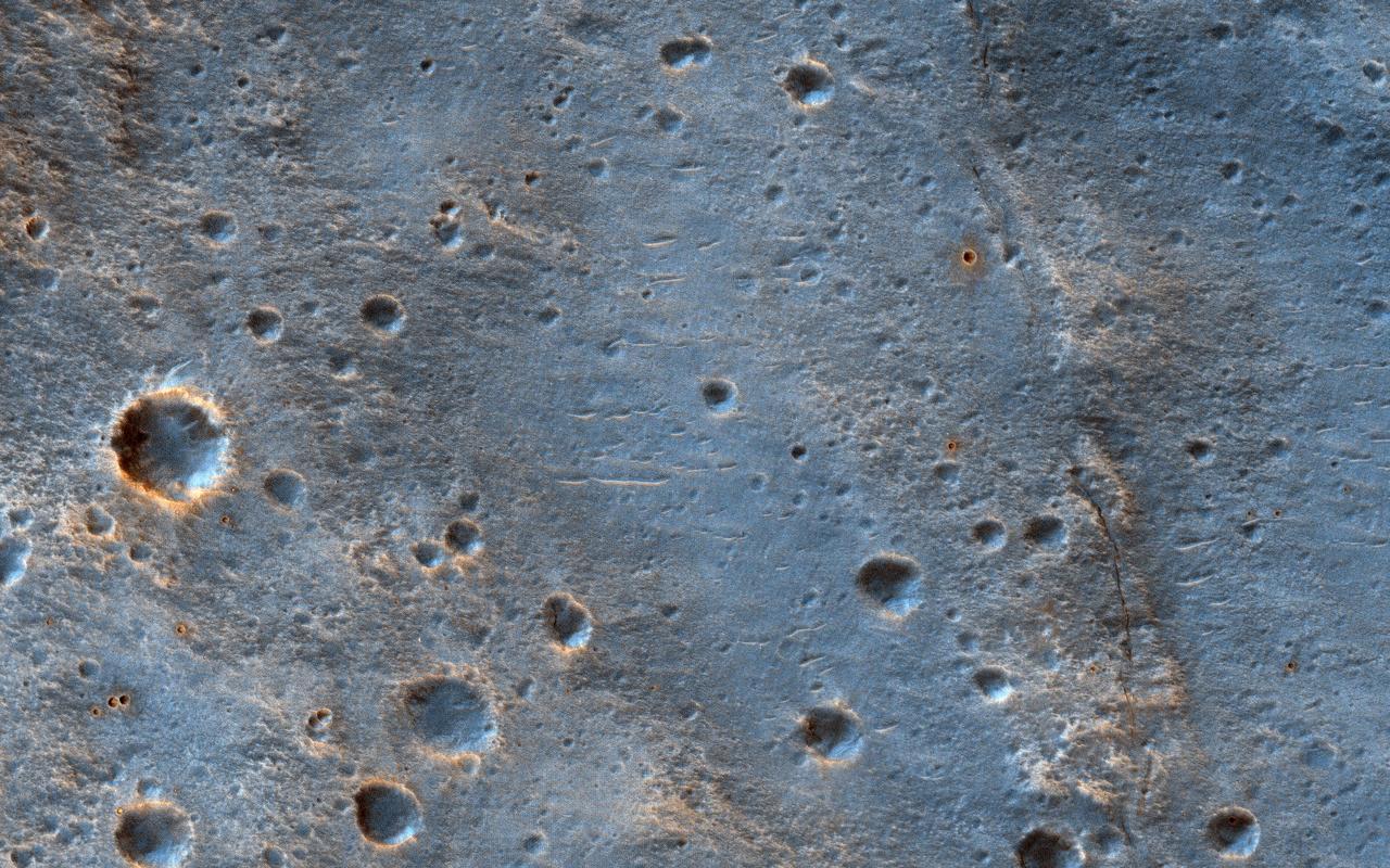 This image shows a cratered area to the southeast of the ExoMars 2020 Rosalind Franklin rover landing site at Oxia Palus. Selecting and characterizing landing sites is a balance between having science targets and avoiding potential obstacles, and HiRISE is used for both purposes. Craters like this one excavate material from within the crust, including both sedimentary and igneous rocks, and scatter this material far from the crater itself. This is one of the ways that so-called "float rocks" (rocks that are not connected to their original outcrop) can occur across a landing site: they are often ejecta from distant impacts. Here, an ejecta blanket is visible in the rays of material surrounding this 2-kilometer diameter crater. The ExoMars rover has a suite of cameras and a close-up imager (called CLUPI) that will be used to study these float rocks. Studying such samples has been an important way of learning about the deep crust of Mars on previous missions, notably the Spirit and Opportunity rovers and now, Curiosity. https://photojournal.jpl.nasa.gov/catalog/PIA23289