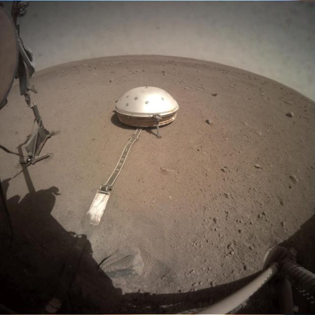 On June 28, 2019, NASA's InSight lander used its robotic arm to move the support structure for its digging instrument, informally called the "mole." This view was captured by the fisheye Instrument Context Camera under the lander's deck.  Lifting the support structure had been done in three steps, a little bit at a time, to ensure the mole wasn't pulled out of the soil. Moving the structure out of the way will give the InSight team a better look at the mole and allow them to try to help it dig.  https://photojournal.jpl.nasa.gov/catalog/PIA23308