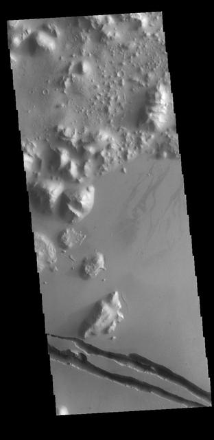 The two linear depressions at the bottom of today's VIS image are part of Cerberus Fossae. The features are termed graben and are formed by crustal extension that allows material to subside between paired tectonic faults. The straight sides and uniform depths are indications that these are tectonic features rather than channels caused by fluid erosion. Orbit Number: 77361 Latitude: 9.90217 Longitude: 161.214 Instrument: VIS Captured: 2019-05-24 05:06 https://photojournal.jpl.nasa.gov/catalog/PIA23327