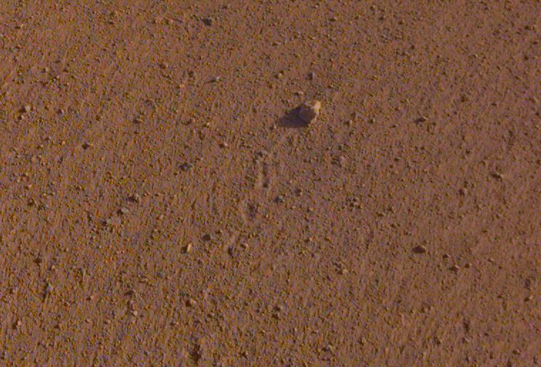 The rock in the center of this image was tossed about 3 feet (1 meter) by NASA's InSight spacecraft as it touched down on Mars on November 26, 2018. The rock was later nicknamed "Rolling Stones Rock" in honor of The Rolling Stones.  A little larger than a golf ball, the rock is about 2.2 inches (5.5 centimeters) in diameter and 1 inch (2.4 centimeters) in height. A series of 10 or so divots marks the rock's course after being set in motion by the landing. It's the farthest NASA has seen a rock roll after landing a spacecraft on another planet.  Though fitting, "Rolling Stones Rock" is not an official designation by the International Astronomical Union, which is responsible to approving the names given to geographical and geological features on other planets.  This image, which has been cropped, was taken by the Instrument Deployment Camera (IDC) on InSight's robotic arm. The uncropped image is provided as well.  https://photojournal.jpl.nasa.gov/catalog/PIA23349