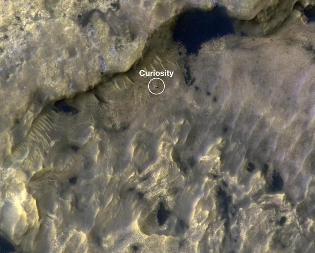 This animation shows the position of NASA's Curiosity rover as it journeyed 1,106 feet (337 meters) through an area of Mount Sharp called "the clay-bearing unit" between May 31 and July 20, 2019. Each of these two images were taken by the HiRISE camera on NASA's Mars Reconnaissance Orbiter. The first image shows the rover, which appears as a gray speck, at a location called "Woodland Bay" (top center). The second shows "Sandside Harbour" (bottom center, near the dark sand patch). Look carefully and you can even see the rover's tracks arcing to the right of the second image. Animation available at https://photojournal.jpl.nasa.gov/catalog/PIA23377